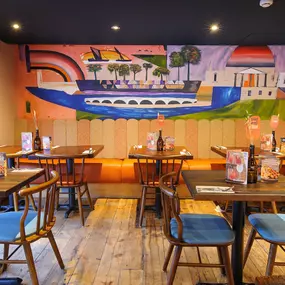 Zizzi Chiswick showcases mural wall above vibrant furnished tables and chairs