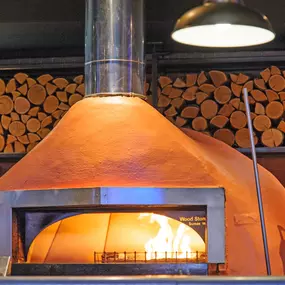 Zizzi Chiswick, showcases wooden tables and chairs beneath decorative copper foliage suspended from the ceiling.