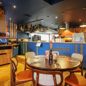 Zizzi Chiswick, showcases wooden tables and chairs beneath decorative copper foliage suspended from the ceiling.