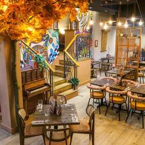 Interior view of the vibrant Zizzi Wigmore Street (near Oxford Street) with modern decor and natural accents.