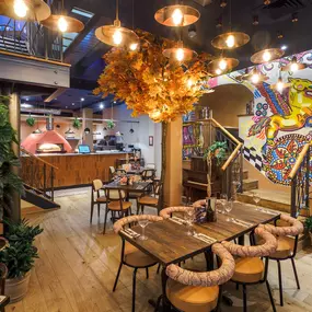 Interior view of the vibrant Zizzi Wigmore Street (near Oxford Street) with modern decor and natural accents.