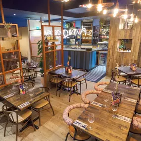 Interior view of the vibrant Zizzi Wigmore Street (near Oxford Street) with modern decor and natural accents.