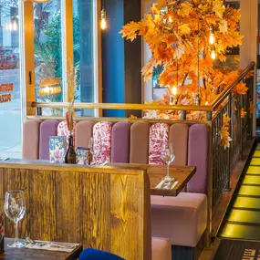 Interior view of the vibrant Zizzi Wigmore Street (near Oxford Street) with modern decor and natural accents.