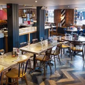 Zizzi Chelmsford, has a warm, contemporary dining area with wood floors, modern decor and natural accents.