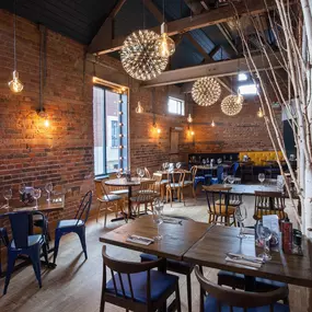 Zizzi Chelmsford, has a warm, contemporary dining area with wood floors, modern decor and natural accents.