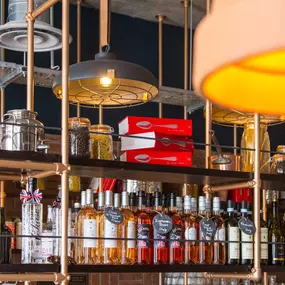 Zizzi Coventry, vibrant dining space with high ceilings and natural light, hanging decor and artistic wall art.