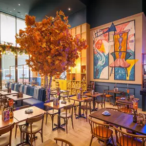 Zizzi High Wycombe, modern-rustic interior with mural art, comfy booths, and open-plan layout.
