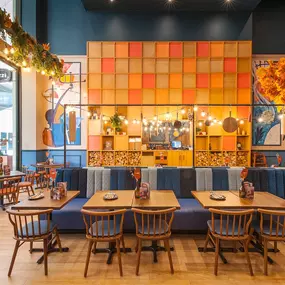 Zizzi High Wycombe, modern-rustic interior with mural art, comfy booths, and open-plan layout.