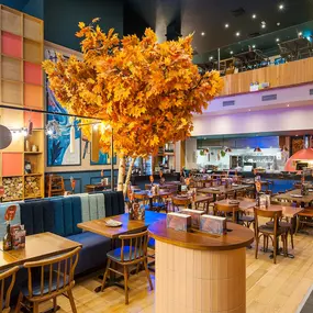 Zizzi High Wycombe, modern-rustic interior with mural art, comfy booths, and open-plan layout.