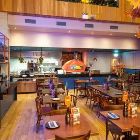 Zizzi High Wycombe, modern-rustic interior with mural art, comfy booths, and open-plan layout.