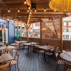 Exterior view of Zizzi St Albans terrace dining under wooden canopy and fairy lighting.