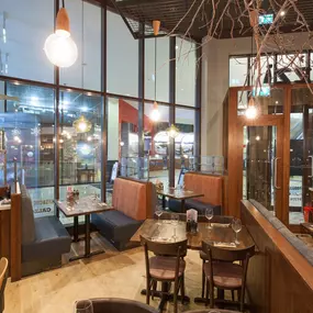 Stylish dining area at Zizzi Cardiff St David's with modern decor and natural accents.