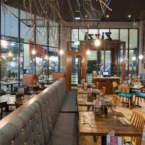 Stylish dining area at Zizzi Cardiff St David's with modern decor and natural accents.
