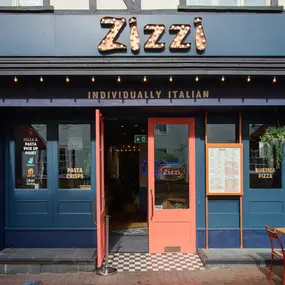 Exterior view of Zizzi Maidstone, located in a historic Tudor building and features an outside dining area protest by awnings.