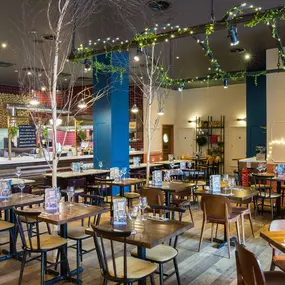 Stylish dining area at Zizzi Manchester Piccadilly with modern decor and natural accents.