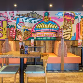 Zizzi Bankside, a vibrant mural and booth seating.