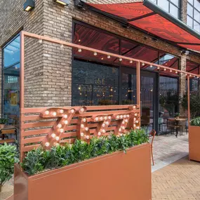 Zizzi Leicester Fosse Park, exterior entrance with greenery wall and outdoor seating.