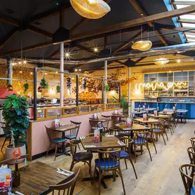 Zizzi Guildford, vibrant dining with oversized foliage art and open layout.