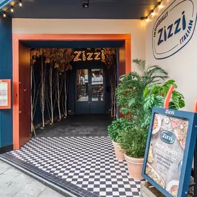 Zizzi Guildford, featuring dark-painted frontage, vibrant orange foliage and Zizzi's iconic signage.