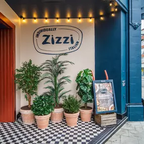 Zizzi Guildford, featuring dark-painted frontage, vibrant orange foliage and Zizzi's iconic signage.