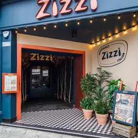 Zizzi Guildford, featuring dark-painted frontage, vibrant orange foliage and Zizzi's iconic signage.