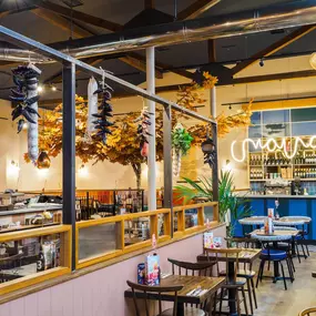 Zizzi Guildford, vibrant dining with oversized foliage art and open layout.
