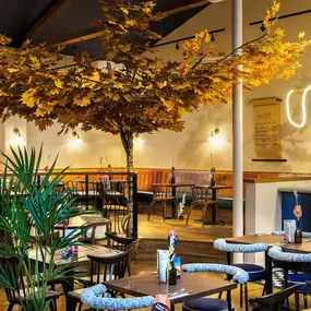 Zizzi Guildford, vibrant dining with oversized foliage art and open layout.