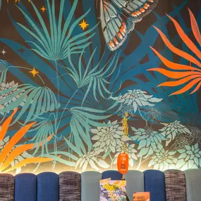 Zizzi Exeter, modern interior with hanging ceiling decor and foliage, and classy wall murals surround the restaurant walls.