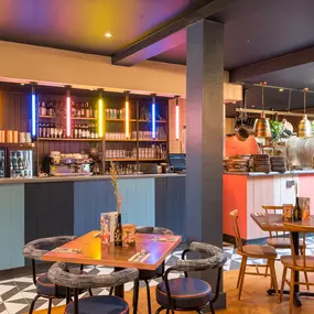 Zizzi Exeter, modern interior with hanging ceiling decor and foliage, and classy wall murals surround the restaurant walls.