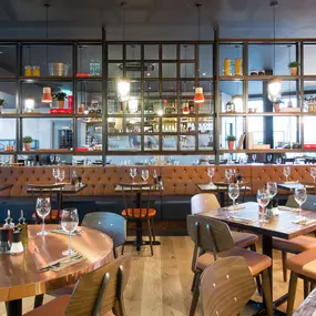 Zizzi Leeds Birstall, interior view of bright, open dining with colourful seating and large windows.