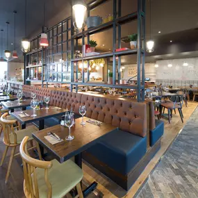 Zizzi Leeds Birstall, interior view of bright, open dining with colourful seating and large windows.