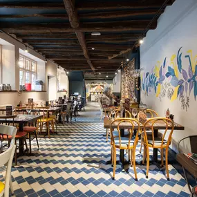 Interior of Zizzi Henley with wooden beams and warm, rustic décor.
