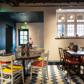 Interior of Zizzi Henley with wooden beams and warm, rustic décor.