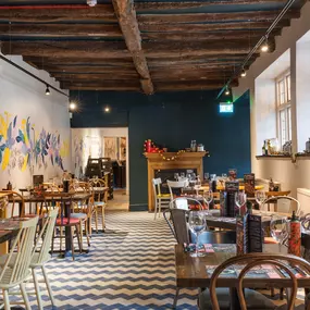 Interior of Zizzi Henley with wooden beams and warm, rustic décor.