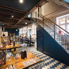 Interior of Zizzi Henley with wooden beams and warm, rustic décor.