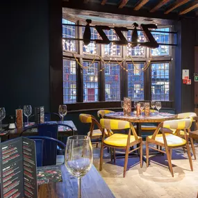 Interior of Zizzi Henley with wooden beams and warm, rustic décor.