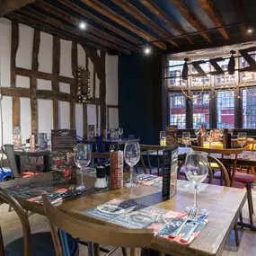 Interior of Zizzi Henley with wooden beams and warm, rustic décor.