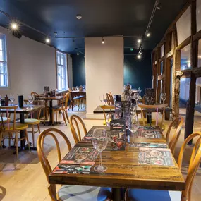 Interior of Zizzi Henley with wooden beams and warm, rustic décor.