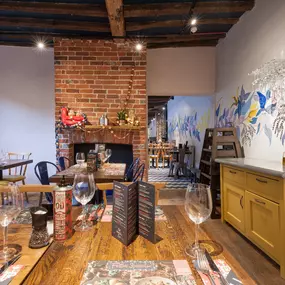 Interior of Zizzi Henley with wooden beams and warm, rustic décor.