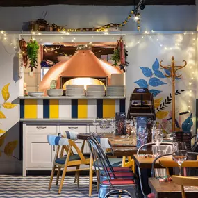 Interior of Zizzi Henley with wooden beams and warm, rustic décor.