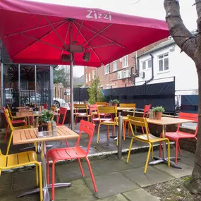 Exterior view of Zizzi Sevenoaks outdoor dining area protected by umbrellas.