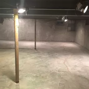 Basement under structural foundation repair with exposed walls and beams