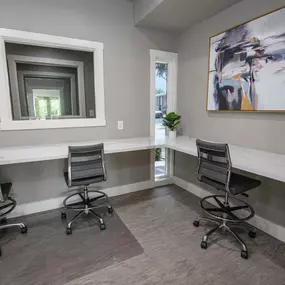 Resident business center with two chairs and a desk and a window