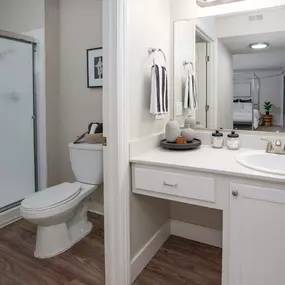 Model apartment bathroom with a shower toilet and sink and a mirror