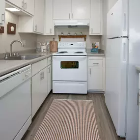 Model apartment kitchen with white appliances and white cabinets