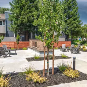 Resident courtyard with benches and trees in front of a fireplace