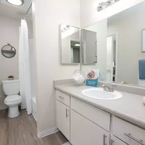 model apartment bathroom with a sink and a mirror and a toilet