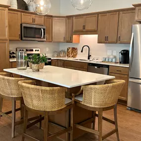 This modern kitchen in a Saint Therese of Corcoran apartment features stainless steel appliances, granite countertops, and ample cabinet space.