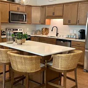 This modern kitchen in a Saint Therese of Corcoran apartment features stainless steel appliances, granite countertops, and ample cabinet space.