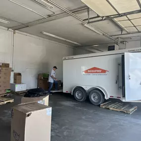 SERVPRO trailer in warehouse; boxes seen on sides